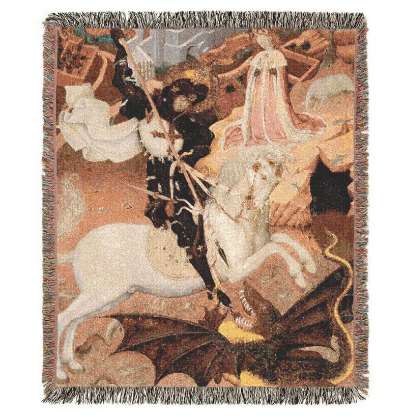 May include: Woven throw blanket featuring a medieval painting of a knight on horseback slaying a dragon. The artwork depicts a knight in black armor, a white horse, and a dragon with brown wings. The blanket has a fringed edge and a beige background.