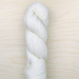 May include: A skein of white yarn, twisted into a spiral shape.