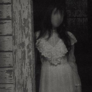 May include: A long-sleeved white dress featuring a high neckline with a prominent lace-trimmed ruffled collar and a fitted bodice. The garment is captured in a grainy, monochromatic aesthetic, highlighting the intricate lace textures and the flowing skirt.