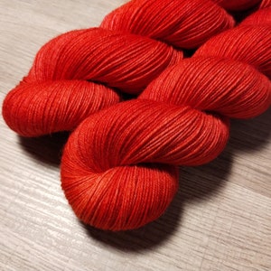 May include: A skein of bright red yarn, wound into a loose coil.