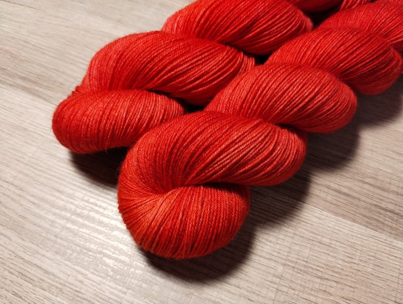 May include: A skein of bright red yarn, wound into a loose coil.