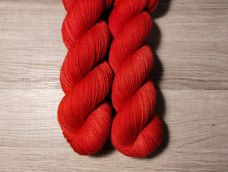 May include: Two skeins of bright red yarn, twisted together.