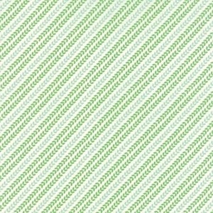 May include: A repeating pattern of diagonal rows of stylized leaves in shades of green and grey-green on a cream background. The design is simple and evokes a natural, organic feel, suitable for fabric or wallpaper.