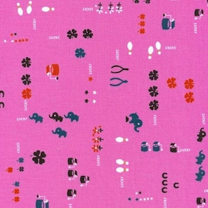 以下が含まれることがあります： 鮮やかなピンク色の生地に、幸運のシンボルが繰り返されるパターン。ボウリングのピン、ゾウ、四つ葉のクローバー、ウィッシュボーン、そして白い文字で「LUCKY」がデザインされています。様々なクラフトプロジェクトに最適です。