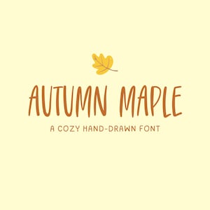 May include: A digital graphic with the words "AUTUMN MAPLE" in brown, handwritten-style font. Above the text is a yellow leaf. Below the text is the phrase "A COZY HAND-DRAWN FONT" in a smaller, brown font. The background is a light yellow.