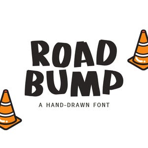 May include: White background with the words "ROAD BUMP" in bold black letters. Below the text is "A HAND-DRAWN FONT". Orange and white traffic cones are placed around the text.
