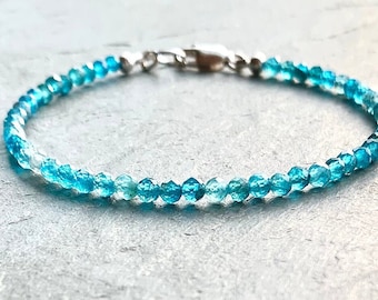 May include: A delicate bracelet made with faceted blue topaz beads. The bracelet has a silver clasp and is perfect for everyday wear.