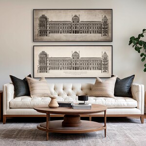 May include: Two black and white framed prints of architectural drawings of a building. The prints are hanging on a white wall above a white tufted sofa with brown throw pillows. A wooden coffee table with a vase and books sits in front of the sofa.