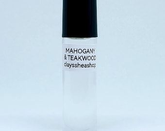 May include: A clear glass roll-on bottle with a black cap. The bottle is labeled "MAHOGANY & TEAKWOOD clayssheashop".