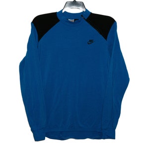 May include: A blue long-sleeve sweatshirt with black shoulder panels and a Nike logo on the front.