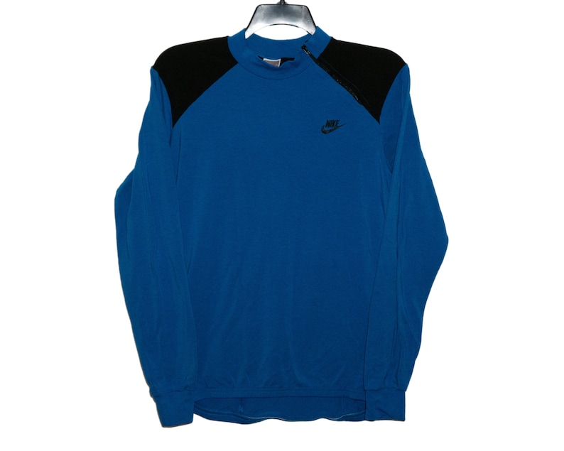 May include: A blue long-sleeve sweatshirt with black shoulder panels and a Nike logo on the front.