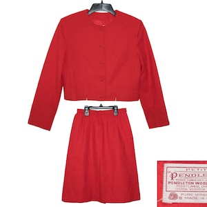 May include: A red wool skirt suit with a cropped jacket and a label that reads "Petite Pendleton, Trade Mark Reg. U.S. Pat. Off., Pendleton Woolen Mills, Portland, Oregon, 100% Virgin Wool, Pure Virgin Wool, Made in U.S.A."