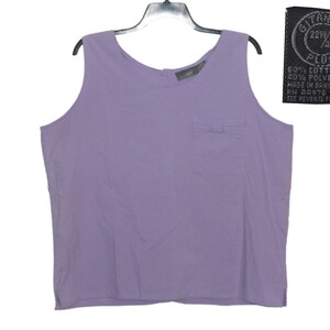 May include: A lavender sleeveless tank top with a small pocket on the front. The tag says "GIZANO 22W/42 PLUS 60% COTTON 40% POLYESTER MADE IN BANGLADESH FN 94976 SEE REVERSE FOR CARE."