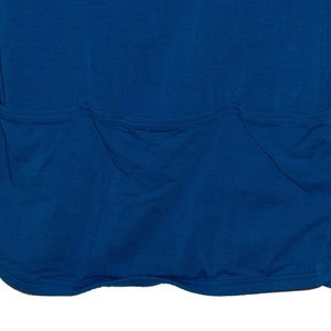 May include: A blue long-sleeved shirt with a single large pocket on the back.