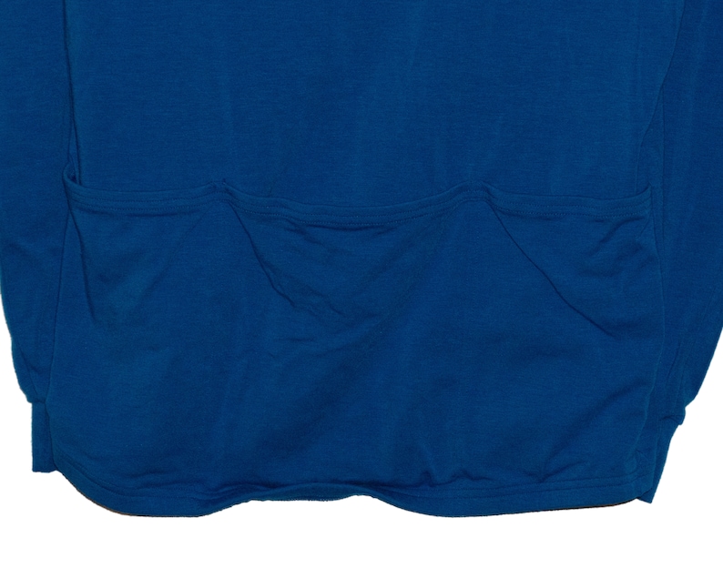 May include: A blue long-sleeved shirt with a single large pocket on the back.