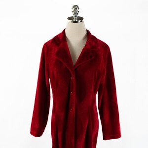 May include: A long-sleeved, red velvet robe with a button-up front and a collar.