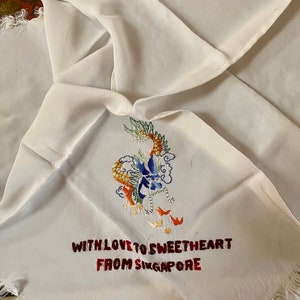 May include: White silk handkerchief with a colorful embroidered dragon and the text "With love to sweetheart from Singapore".