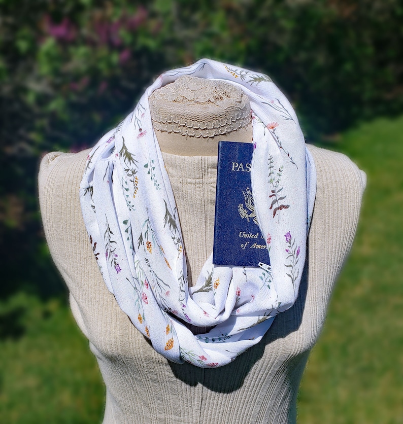 Dainty stems of wildflowers in various colors on a creamy white background with a hidden zippered pocket.