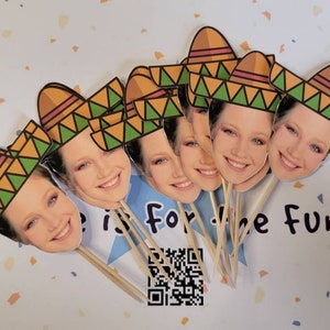 May include: A set of 7 cupcake toppers featuring a smiling face with a colorful sombrero hat. The toppers are made of cardstock and are perfect for adding a festive touch to your next party.