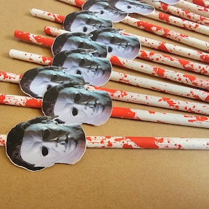 Pu&ograve; includere: Un set di cannucce di carta a strisce bianche e rosse con un design a spruzzo di sangue. Ogni cannuccia ha un'immagine stampata della maschera di Michael Myers dei film di Halloween.