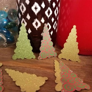 Puede incluir: Surtido de adornos de papel con forma de &aacute;rbol de Navidad con purpurina. Algunos son verdes y otros son rojos y verdes con un patr&oacute;n de espiral.