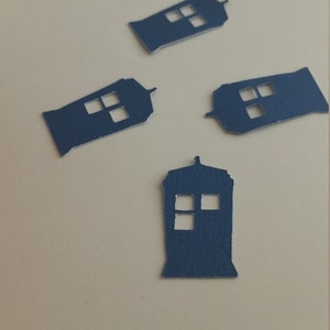 May include: Four blue paper cutouts of the TARDIS, the time machine from the Doctor Who television series. The cutouts are on a white background.