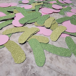 May include: A pile of green and pink glitter paper cutouts in the shape of pickles and circles.