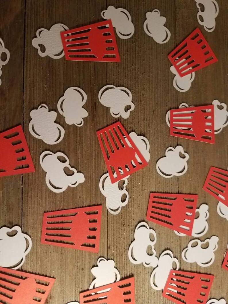 May include: Red and white paper cutouts of popcorn and popcorn boxes. The popcorn cutouts are white and the popcorn boxes are red with white stripes.