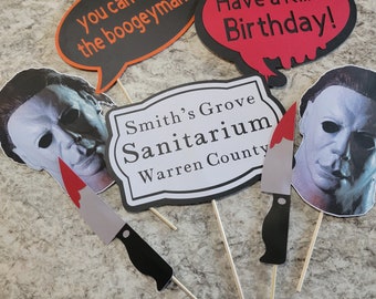 Può includere: Un set di cinque accessori per foto booth di Halloween con un coltello, un cartello che dice "Smith's Grove Sanitarium Warren County" e tre fumetti con il testo "You can't kill the boogeyman!" e "Have a Killer Birthday!"