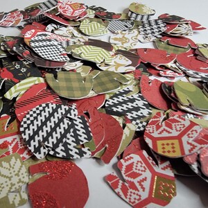 May include: A pile of red, green, and white paper mitten shapes with various patterns. The mittens are made of paper and have a festive holiday theme.