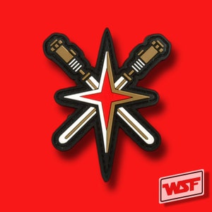 May include: A patch in black, white, gold, and red, featuring a starburst design with crossed swords. The star has a red centre and gold outline. The swords are gold with white and black details. The background is red.