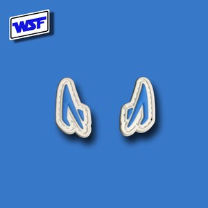 Pu&ograve; includere: Due toppe di tessuto blu e bianco a forma di una lettera A stilizzata. Le toppe hanno un contorno bianco e un interno blu.