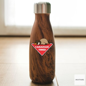 Pu&ograve; includere: Una borraccia isolante marrone e argento con un motivo a venature del legno. Un adesivo triangolare rosso con le parole "CANADIAN TIRED" e un cartone animato di un'oca &egrave; attaccato alla bottiglia. La bottiglia ha un tappo argentato.