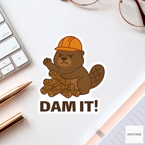 Puede incluir: Una pegatina con un castor de dibujos animados que lleva un casco naranja y sostiene troncos. El texto "DAM IT!" está debajo del castor. La pegatina es marrón, naranja y blanca.