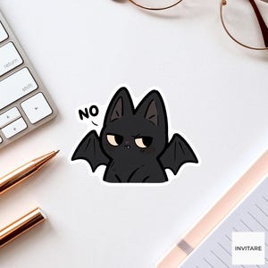 May include: A die-cut sticker featuring a black bat with large pointed ears, pale eyes, and a small fang, displaying a grumpy expression with the word NO printed in black text above its left wing, outlined in a thick white border.