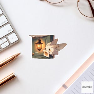 May include: A die-cut sticker featuring a small, fluffy, white moth-like creature with large dark eyes, holding a small square card. The creature is positioned next to a dark green door frame with a glowing, lit lantern hanging from the top corner.