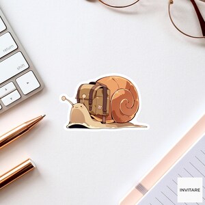 May include: A die-cut sticker featuring a light brown snail with a tan backpack strapped to its shell. The snail has a simple face with two eyes on stalks and a small smile. The backpack is rectangular with dark brown straps and buckles.