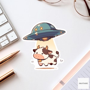 May include: A sticker featuring a cartoon cow being abducted by a UFO. The UFO is teal with yellow lights, and the cow is white with brown spots and a bell. The background is white.