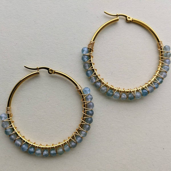 Natural blue apatite stone beads wire wrapped in gold stainless steel hoops.