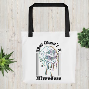 Puede incluir: Bolsa de tela blanca con asas negras y un gráfico de una calavera derritiéndose con el texto "That wasn't a Microdose" en negro.