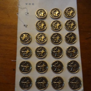 ¿Placa de 22 bonitos botones de metal dorado de 2 cm de diámetro sobre cartón original marca VOG antigua representación de Sagitario? Árbitro: K