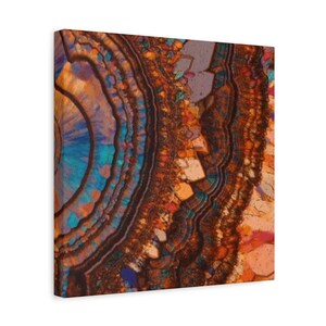 May include: A canvas print featuring a close-up of a cross-section of a mineral, showcasing concentric bands of color. The artwork displays a palette of warm browns, oranges, and blues, with intricate details and textures. The print is mounted on a wooden frame.