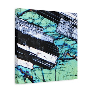 May include: A canvas print featuring a close-up of a mineral structure. The artwork displays a complex pattern of black, white, and blue crystalline formations against a green background. The image has a textured appearance, with visible details of the mineral's internal structure.