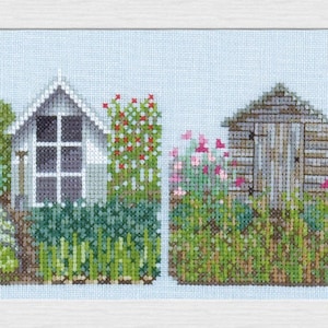 May include: A row of five colorful garden sheds with different styles and colors, surrounded by lush green foliage and flowers.