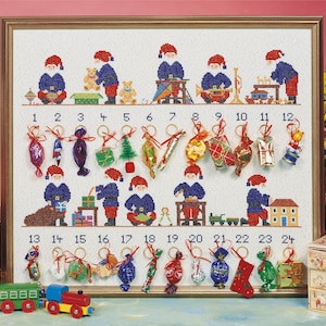 Peut inclure: Un calendrier de l'avent brodé en point de croix blanc avec 24 poches numérotées. Chaque poche représente un petit Père Noël et un petit cadeau. Le calendrier est encadré d'un cadre doré.