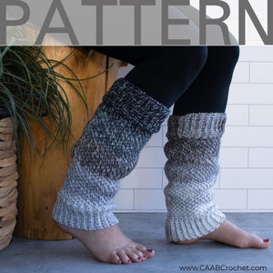 May include: A pair of gray and white knitted leg warmers with a ribbed cuff and a gradient color pattern. The leg warmers are worn over black leggings. The word "PATTERN" is at the top of the image.
