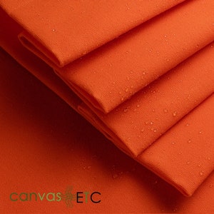 May include: Close-up of a stack of orange canvas fabric with water droplets on the surface. The fabric is folded and has a smooth texture. The text "canvas ETC" is visible in the bottom left corner of the image.