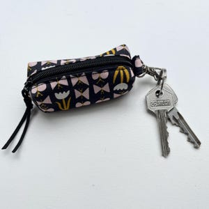 Pequeño llavero floral en blanco, negro y rosa para accesorios como auriculares, Airpods, lápiz labial, bálsamo labial y llaves.