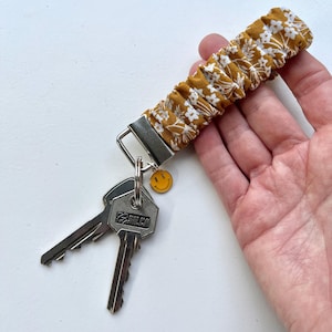 Llavero elástico para sujetar a tu muñeca. En amarillo ocre. Una especie de coletero para la muñeca; Ideal para sujetar tus llaves a