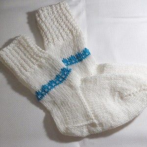 K&ouml;nnte beinhalten: Ein Paar wei&szlig;e Stricksocken mit einem blauen Streifen &uuml;ber dem Schaft jeder Socke.